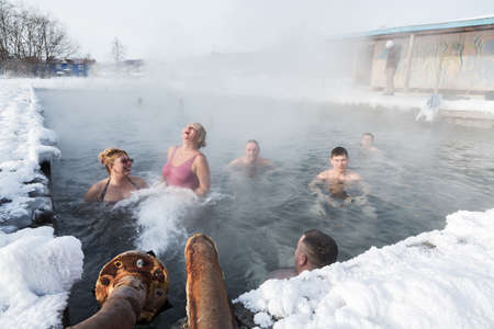 KAMCHATKA PENINSULA, RUSSIA - FEB 02, 2013: A group of people relaxing in the winter in the pool with natural thermal mineral water. Eurasia, Russian Far East, Kamchatsky Krai, Anavgay Village.のeditorial素材