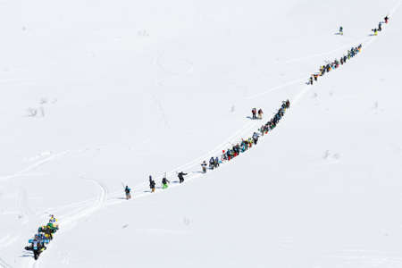 KAMCHATKA PENINSULA, RUSSIAN FEDERATION - MARCH 9, 2014: Group of sportsmens - skiers and snowboarders climbing the mountain for freeride. Competition Kamchatka Freeride Open Cup on Far East Russia.のeditorial素材