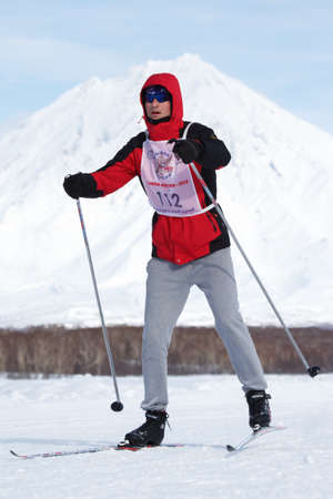 PETROPAVLOVSK CITY, KAMCHATKA PENINSULA, RUSSIAN FAR EAST - FEB 10, 2018: Skier running along the winter ski track on background of Koryak Volcano. All-Russia mass ski race - Ski Track of Russia.のeditorial素材