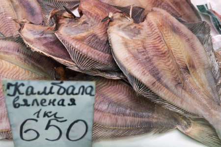 PETROPAVLOVSK CITY, KAMCHATKA PENINSULA, RUSSIAN FAR EAST - 20 MAY, 2018: Close-up view of dried salted flatfish with price on counter at fish market. Concept: delicious, fish market, Asian cuisine.のeditorial素材