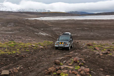 KAMCHATKA PENINSULA, RUSSIA - SEPTEMBER 17, 2016: Extreme off-road expedition car Toyota Land Cruiser Prado driving on mountain road on background of volcanic landscape in overcast autumn weather.のeditorial素材