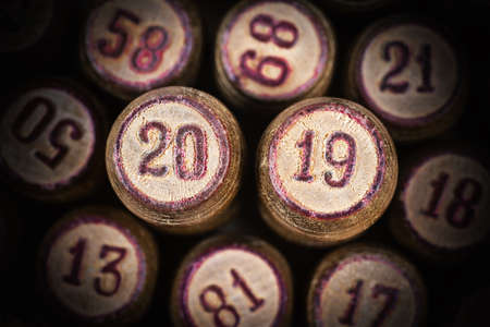Wooden vintage lotto kegs with two numbers 20 and 19 as symbol of 2019 year. Close-up top view of 2019 New Year inscription in circle with pink trim. Vignette and trendy brown toning.の写真素材
