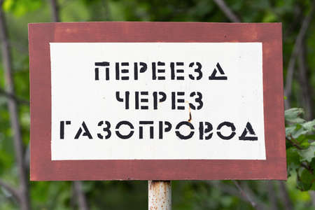 KAMCHATKA PENINSULA, RUSSIA - AUGUST 7, 2019: Warning sign in area of passage of gas main Public Joint Stock Company Gazprom (Gazprom PJSC), inscription in Russian:のeditorial素材