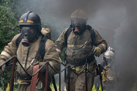 KAMCHATKA PENINSULA, RUSSIA - AUG 7, 2019: Firefighters of Fire Department â 1 of Federal Fire Service in Kamchatka Territory during fire extinguishing, training to overcome fire zone of psychological training for firefighters.のeditorial素材