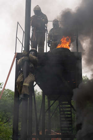 PETROPAVLOVSK-KAMCHATSKY, KAMCHATKA PENINSULA, RUSSIA - AUG 7, 2019: Firefighters of Fire Department â 1 of Federal Fire Service in Kamchatka during fire extinguishing, training to overcome fire zone of psychological training for firefighters.のeditorial素材