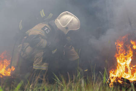 KAMCHATKA PENINSULA, RUSSIA - AUG 7, 2019: Firefighters of Fire Department â 1 of Federal Fire Service in Kamchatka Territory during fire extinguishing, training to overcome fire zone of psychological training for firefighters.のeditorial素材