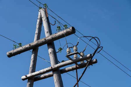 Electricity distribution, high-voltage power pole with wires on insulators against clear cloudless...