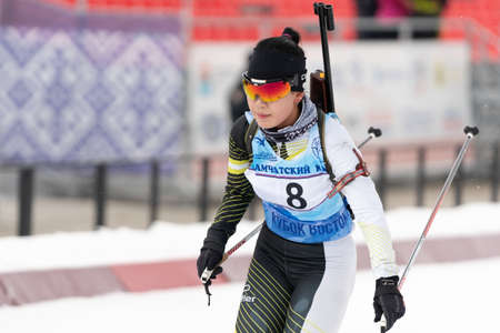 Korean sportswoman biathlete Lee Hyunju (South Korea) skiing at finish after rifle shooting during Open regional youth biathlon competitions East Cup. Kamchatka Peninsula, Russia - Apr 12, 2019.のeditorial素材