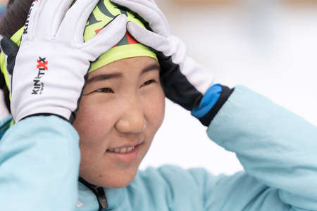 Portrait of sportswoman biathlete Munkhbat Doljinsuren Mongolia after rifle shooting and skiing. Open regional youth biathlon competitions East Cup. Kamchatka Peninsula, Russia - April 12, 2019.のeditorial素材
