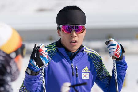 Portrait of Korean sportsman biathlete Yang Seon Jik South Korea in shooting range before rifle shooting, skiing. Junior biathlon competitions East of Cup. Kamchatka Peninsula, Russia - April 14, 2019のeditorial素材