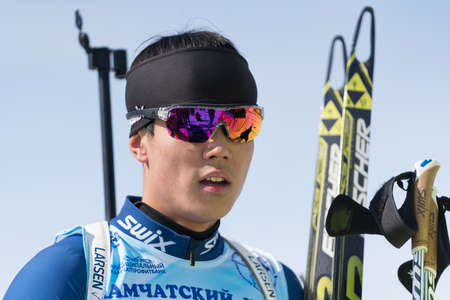 Portrait of Korean sportsman biathlete Yang Seon Jik South Korea at finish after skiing and rifle shooting. Junior biathlon competitions East of Cup. Kamchatka Peninsula, Russia - April 14, 2019.のeditorial素材