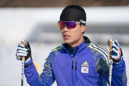 Korean sportsman biathlete Yang Seon Jik South Korea in shooting range biathlon stadium before skiing and rifle shooting. Junior biathlon competitions East of Cup. Kamchatka, Russia - April 14, 2019のeditorial素材