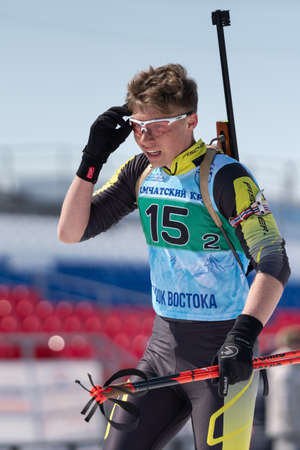 Sportsman biathlete Artem Khanzutin skiing on ski track distance biathlon stadium during Junior biathlon competitions East Cup. Petropavlovsk City, Kamchatka Peninsula, Russian Far East - Apr 14, 2019のeditorial素材