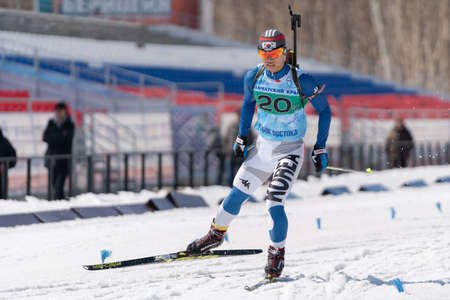 Korean sportsman biathlete Cheon Yunpil South Korea skiing on ski track distance biathlon stadium. Junior biathlon competitions East of Cup. Petropavlovsk, Kamchatka Peninsula, Russia - April 14, 2019のeditorial素材