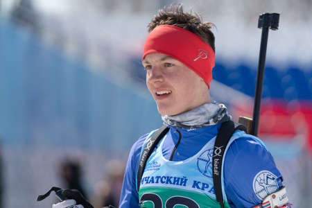 Portrait of sportsman biathlete Sporshev Nikita at finish after rifle shooting and skiing. Junior biathlon competitions East of Cup. Petropavlovsk-Kamchatsky City, Kamchatka, Russia - April 14, 2019.のeditorial素材