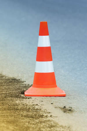 Warning traffic road cone stand on street asphalt city highway during road restoration and road repairing, asphalt pavement works on road.の写真素材