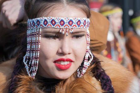 Portrait pretty smiling female in traditional clothing indigenous inhabitants of Kamchatka. Celebration Koryak national ritual holiday Hololo Day of Seal. Kamchatka Region, Russia - Nov 4, 2018のeditorial素材