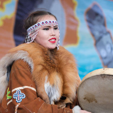 Girl dancing with tambourine in tradition clothing aborigine people Kamchatka Peninsula. Concert, celebration Koryak national ritual holiday Day of Seal - Hololo. Kamchatka, Russia - November 4, 2018のeditorial素材