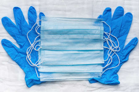 Lot medical respiratory face masks on blue gloves as background. World pandemic insurance, airborne...