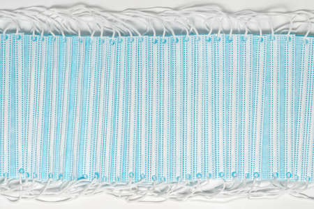 Medical and surgical face masks on white background. Close-up view of lot blue disposable...