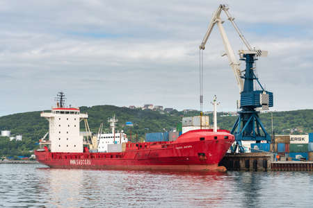 Portal crane unloading cargo container ship Sasco Angara Russian Sakhalin Shipping Company at pier...