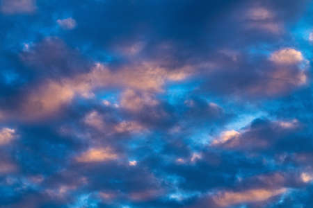 Amazing clouds in blue sky, illuminated by rays of sun at sunset to change weather. Soft focus,...