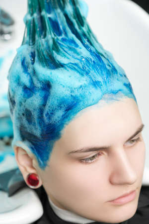 Head of young woman with blue hair while shampooing her head in professional beauty salon after dyeing her sapphire hair.の写真素材