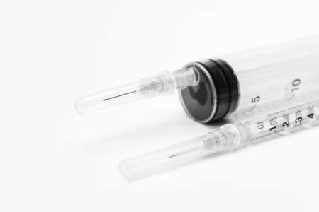 Two medical syringes for vaccine injection on white background. Close-up of large and small syringe. Selective focus.の写真素材
