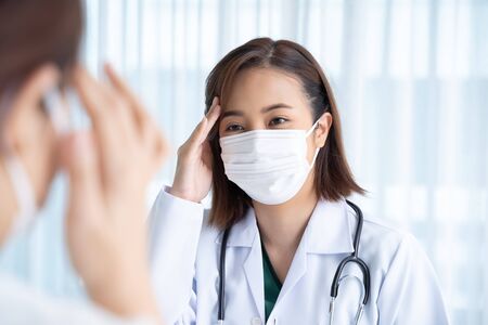 The doctor asks about the symptoms of patients in the examination room.の写真素材