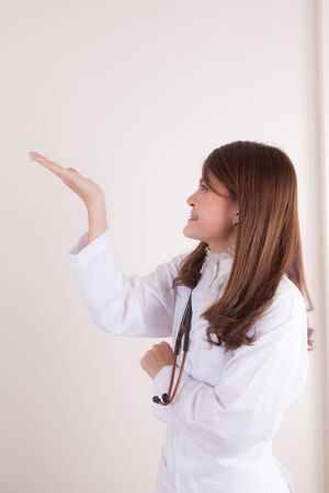 Beautiful successful female doctor holding something on her handsの写真素材