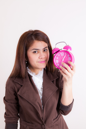 Surprised girl shows the alarm clock in a handの写真素材