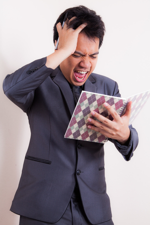 A businessman struggling trying to solve a problemの写真素材