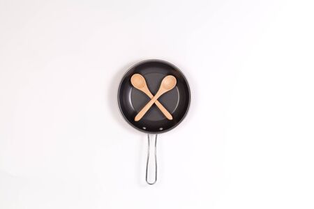 Cross wood flipper Or spoon with frying pan  isolated on white backgroundの写真素材