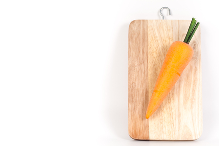 A view looking down on  an carrot on a worn butcher block cutting board isolated on whiteの写真素材