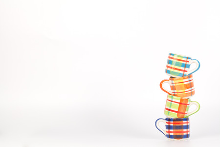 Tower of colorful Scotch pattern cups isolated on whiteの写真素材