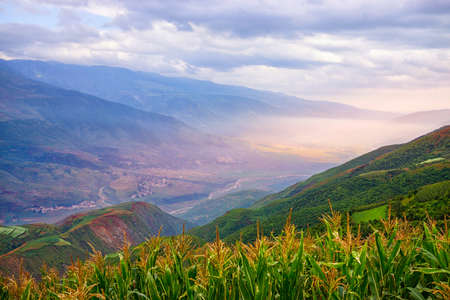 Agriculture and livestock land village in the mountain pass at countryside of Dong Chuan, yunnan one of the landmarks in Kunming, China.(With fog, mist effect in rainy season and blur foreground.)の写真素材