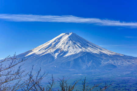 Stunning view of Fuji mountain taken from Kawaguchiko mt's scenic point, in clear blue sky with haze and smoke effect  at the bottom of mountain.の写真素材