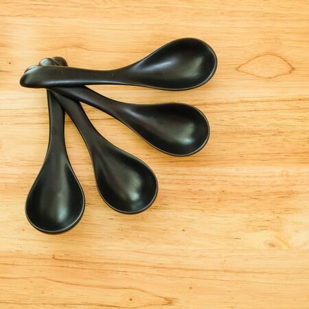 four black spoon on woodの写真素材