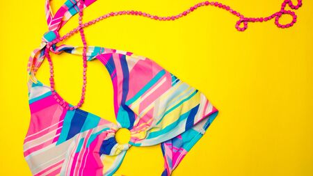 Swimsuit and pink wooden beads for summer timeの写真素材