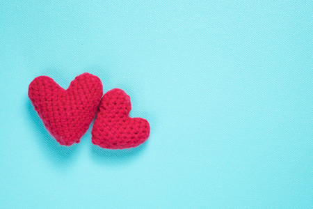 Red crochet hearts on on blue backgroundの写真素材