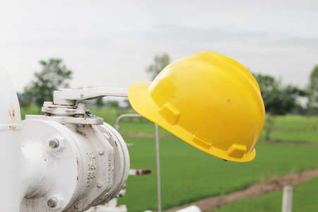 Yellow hard hat on hand wheel valveの写真素材