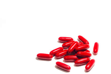 Red pills and pill bottle on white isolated