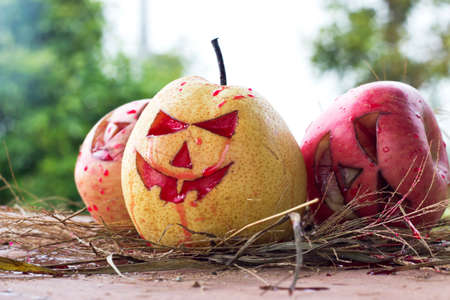 Chinese pear and apple for halloween on hayの写真素材