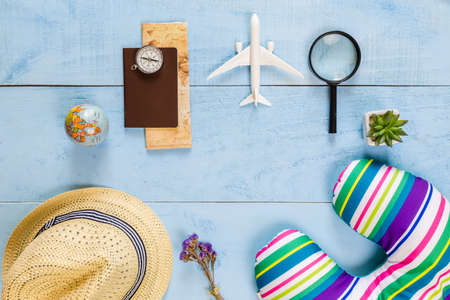 Top view essential travel items. map, passport, airplane, blue wooden background.Free space for creative design text and word.Flat lay different object for mock up.の写真素材