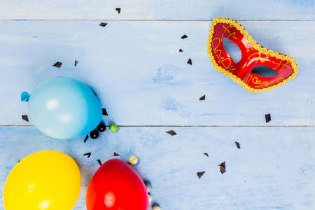 Flat lay top veiw of mask party preparation accessories. cosmetics and brushes on blue wooden backgroundの写真素材