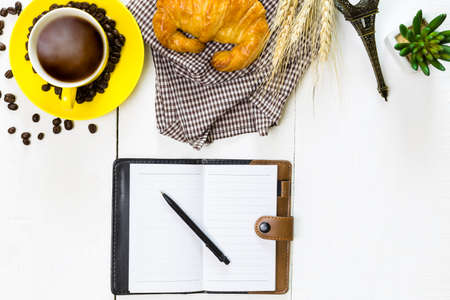 top view business breakfast with coffee and croussant. Rustic white wooden background with copy spaceの写真素材