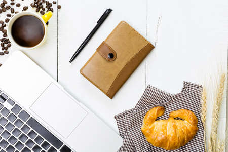 top view business breakfast with coffee and croussant. Rustic white wooden background with copy spaceの写真素材