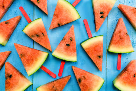 summer concept watermelon slice ice lolly on a blue rustic wood backgroundの写真素材
