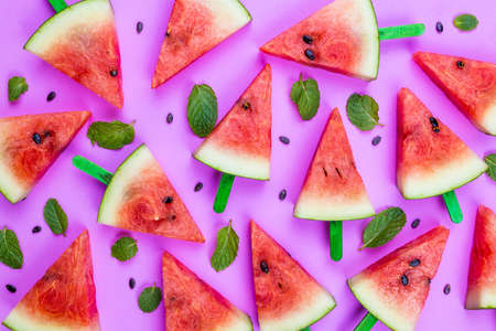 summer concept watermelon slice ice lolly on a pink backgroundの写真素材