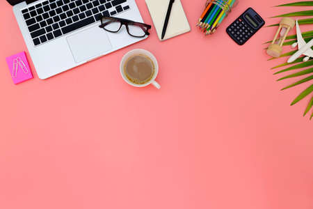 Flat lay office workspace with blank laptop, clipboard, eucalyptus branches on pink background. top...